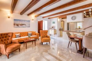 Una sala de estar con un sofá y sillas y una mesa. en Villa Frana, en Krk