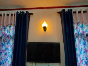 a light on a wall with a mirror and a television at Abhi Villa in Beruwala +32 photos
