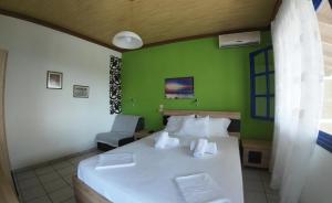 a bedroom with a white bed and a green wall at Studios Ntina in Alyki