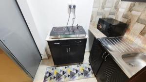 a small kitchen with a stove and a sink at Family Room in Abu Dhabi