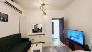 a living room with a couch and a flat screen tv at Family Room in Abu Dhabi