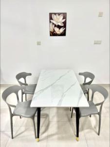 a white marble table and chairs in a room at Astetica Residence in Serdang