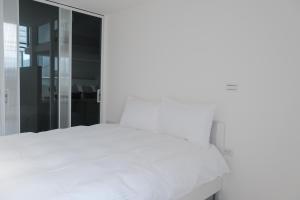 a bedroom with a white bed and a glass wall at 8 hundred million in Anping