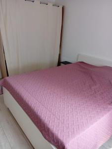 La Celle-sous-GouzonにあるMaison 1- entre ville et verdureのピンクの掛け布団付きのベッド1台