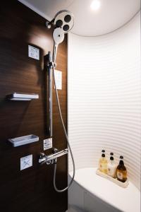 a shower in a bathroom with a white sink at Fukuoka Airport WEST in Shime