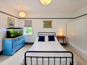 a bedroom with a bed and a fish tank at Pass the Keys 4-Bedroom Retreat in Radyr wLush Gardens Parking in Cardiff