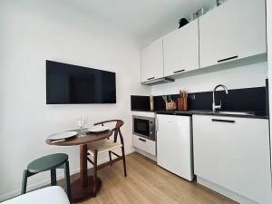 ランスにあるReims résidence inn Sharies Studio équipé C201のテーブル付きのキッチンと白いキャビネット付きのキッチン +13枚の写真