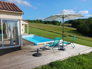 eine Terrasse mit zwei Stühlen und einem Sonnenschirm neben einem Pool in der Unterkunft Domaine de la Marandine in Le Vigan