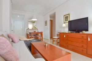 a living room with a couch and a tv on a dresser at Magic Sunset View in El Borseral