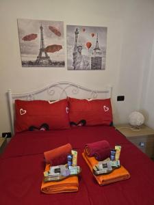 a bedroom with a bed with red sheets and two towels at Casa vacanze il Gelsomino in Abbadia San Salvatore