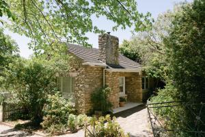 a stone house with a chimney on top of it at Stone Gate Cottage in Aldgate