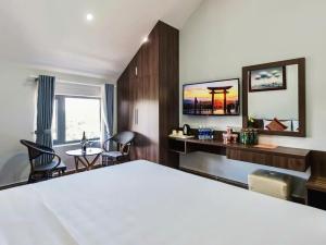 a hotel room with a bed and a desk and a table at Tiên Hoa Sơn Villa in Da Lat