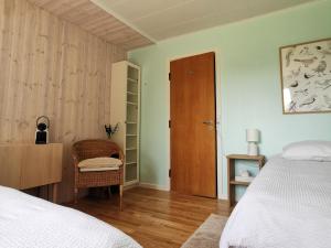 a bedroom with a bed and a chair and a door at TheGilgahouse Familyroom! in Nakskov