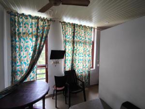 a room with a table and chairs and a window at Queens INN in Kodungallūr