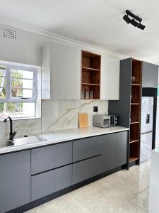 a kitchen with white cabinets and a sink at Lux Sleek City Haven in Cape Town