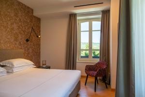 a hotel room with a bed and a window at Villaggio Narrante - Le Case dei Conti Mirafiore in Serralunga d'Alba