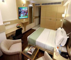 a hotel room with a bed and a tv at Hotel Hampton International Near Delhi Airport in New Delhi