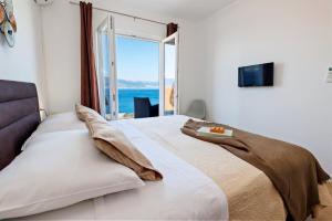 een slaapkamer met een bed met uitzicht op de oceaan bij Vila Perla Slatine in Slatine +49 foto's