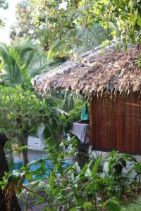 a hut with a thatched roof in a garden at Tantawan sea view residence 山海居 in Salad Beach
