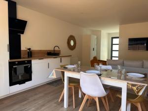 eine Küche und ein Wohnzimmer mit Tisch und Stühlen in der Unterkunft La Drôme - Gîtes du Bessin in Balleroy + 10 Fotos