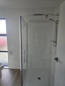 a shower with a glass door in a bathroom at Family home in Rolleston +4 photos