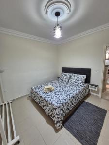 a bedroom with a bed with a black and white comforter at Cozy Apartment in Monastir