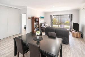a living room with a table and a couch at The Foxes Den- secure yard, WIFI in Geographe