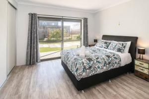 a bedroom with a bed and a large window at The Foxes Den- secure yard, WIFI in Geographe
