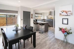 a dining room and kitchen with a black table and chairs at The Foxes Den- secure yard, WIFI in Geographe +5 photos