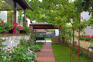 een tuin met bloemen en een stenen loopbrug bij Ana's home in Sibiu