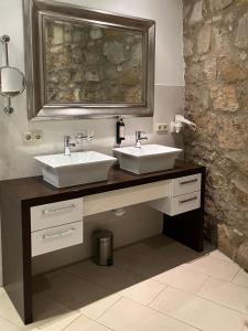 a bathroom with two sinks and a mirror at Hotel & Spa Wasserschloss Westerburg in Westerburg