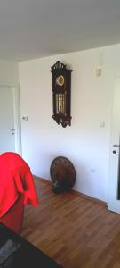 Un reloj en la pared de una habitación con suelo de madera. en Cherry Apartment, en Sarajevo