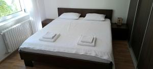 Un dormitorio con una cama con dos toallas encima. en Cherry Apartment, en Sarajevo