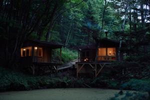 a cabin in the middle of a forest at night at ist - Aokinodaira Field in Kawakami