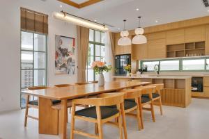 a kitchen with a large wooden table and chairs at La isla Apartments & Villas - Sea View & Fireworks Phu Quoc in Phu Quoc