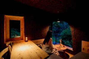 a woman sitting at a table in a room with a window at ist - Aokinodaira Field in Kawakami +77 photos