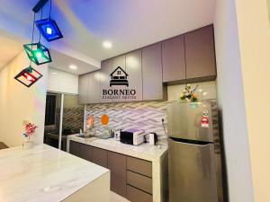 サンダカンにあるBorneo Elegant suites Borneo Coveの冷蔵庫とカウンターのあるキッチン