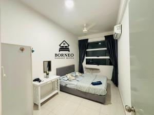 サンダカンにあるBorneo Elegant suites Borneo Coveのベッドと机と窓のある寝室