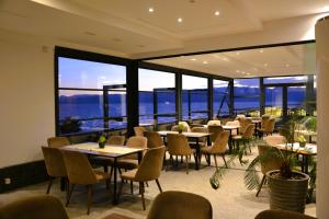 a restaurant with tables and chairs and a view of the water at Park Lakeside Ohrid in Ohrid