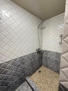 a bathroom with a shower with a tiled wall at Chorsu Old City in Tashkent