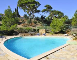 a large swimming pool with blue water in a yard at Chambres d'hôtes balnéo Château de Jonquières in Narbonne