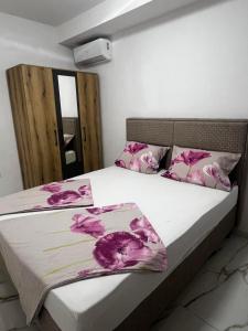 a bedroom with a bed with pink flowers on it at Kan&Dzan Apartmani in Ulcinj