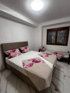 a bedroom with two beds with pink flowers on the sheets at Kan&Dzan Apartmani in Ulcinj +20 photos