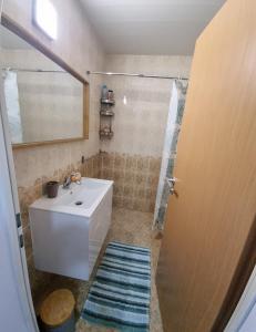 een badkamer met een witte wastafel en een spiegel bij Port Natura Apartment in Varna