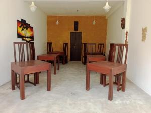a group of wooden tables and chairs in a room at Monarathanna in Talalla South