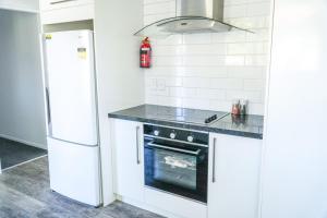a kitchen with a stove and a refrigerator at Richmond Heights apartment in Taupo