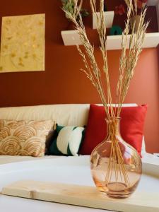 a glass vase sitting on a table with flowers in it at La Perle - Jacuzzi Balneo- Wifi - Parking PV in Lunel