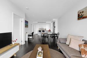 a living room with a couch and a table at Stylish 2BR with Story Bridge & Fireworks Views in Brisbane