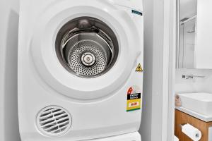 a washing machine in a bathroom next to a sink at Stylish 2BR with Story Bridge & Fireworks Views in Brisbane