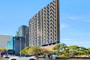 a white car parked in front of a tall building at Stylish 2BR with Story Bridge & Fireworks Views in Brisbane